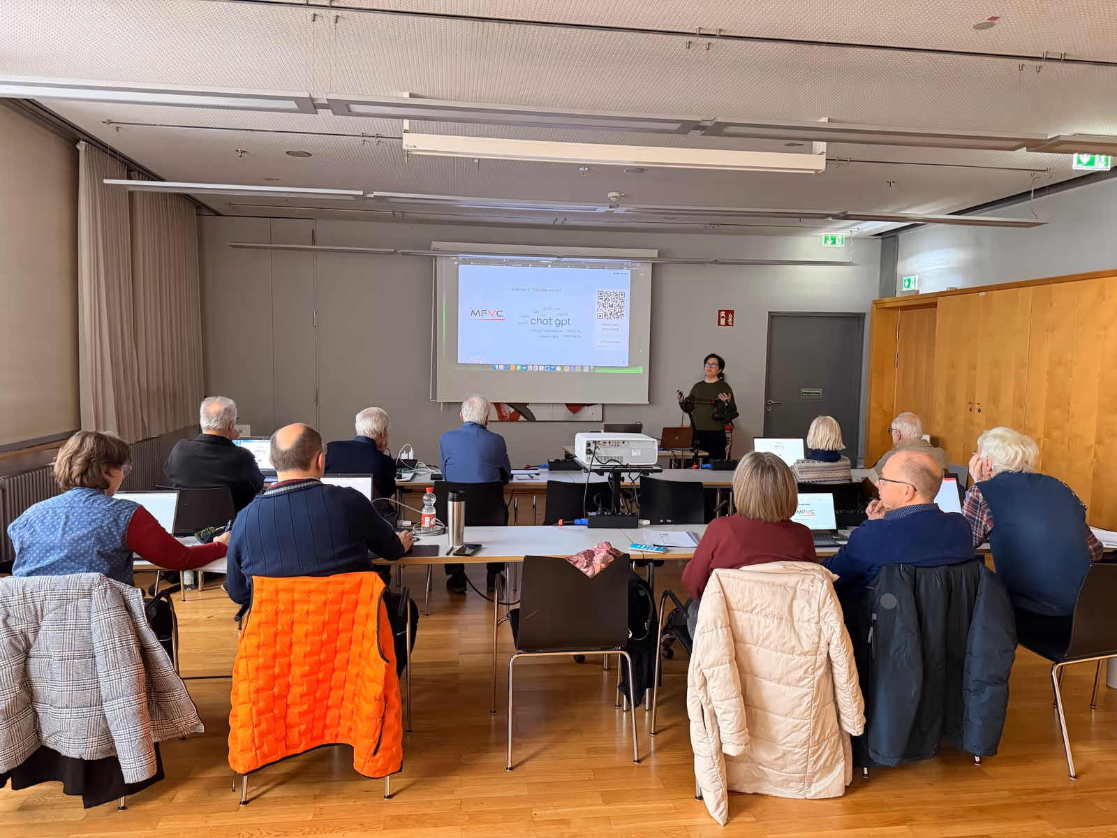 Seminarraum in der Stadthalle Germering: Filipa Campos Viola steht vor der Leinwand, elf Teilnehmer sitzen mit Laptops davor